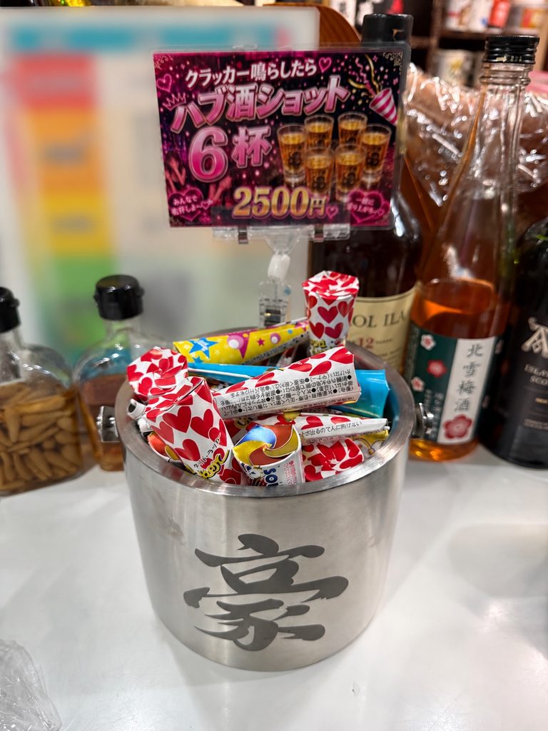 Party poppers and a sign for the six-shot habu liquor set at GOU Zemusuzaka